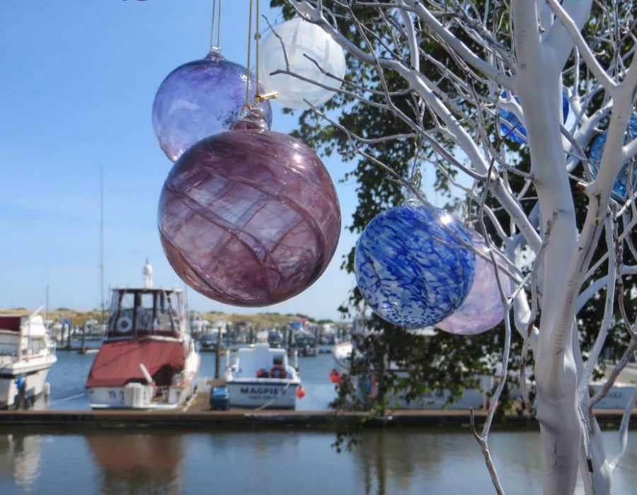 Image of an assortment of colorful glass floats still entwined in a pale net.