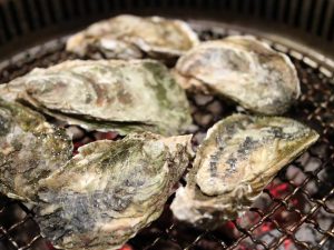 An image of oysters being grilled.