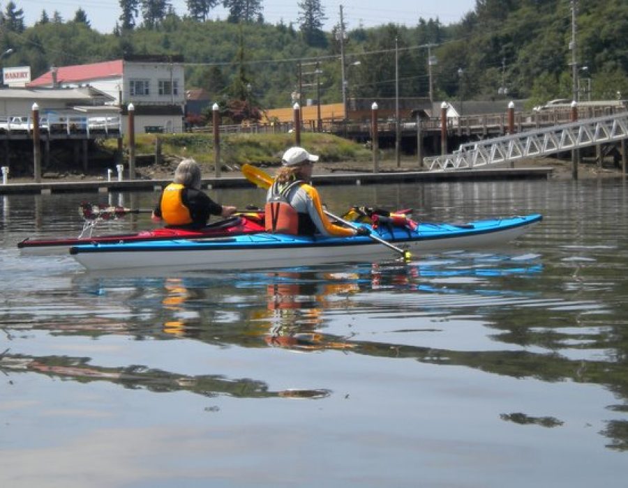 An image of two sports enthusiasts canoeing together on the lake.