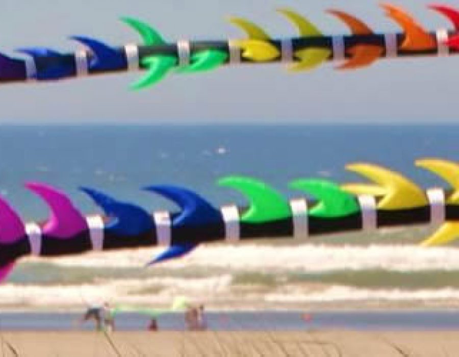 An Image of two colorful kites string along a string in the wind.