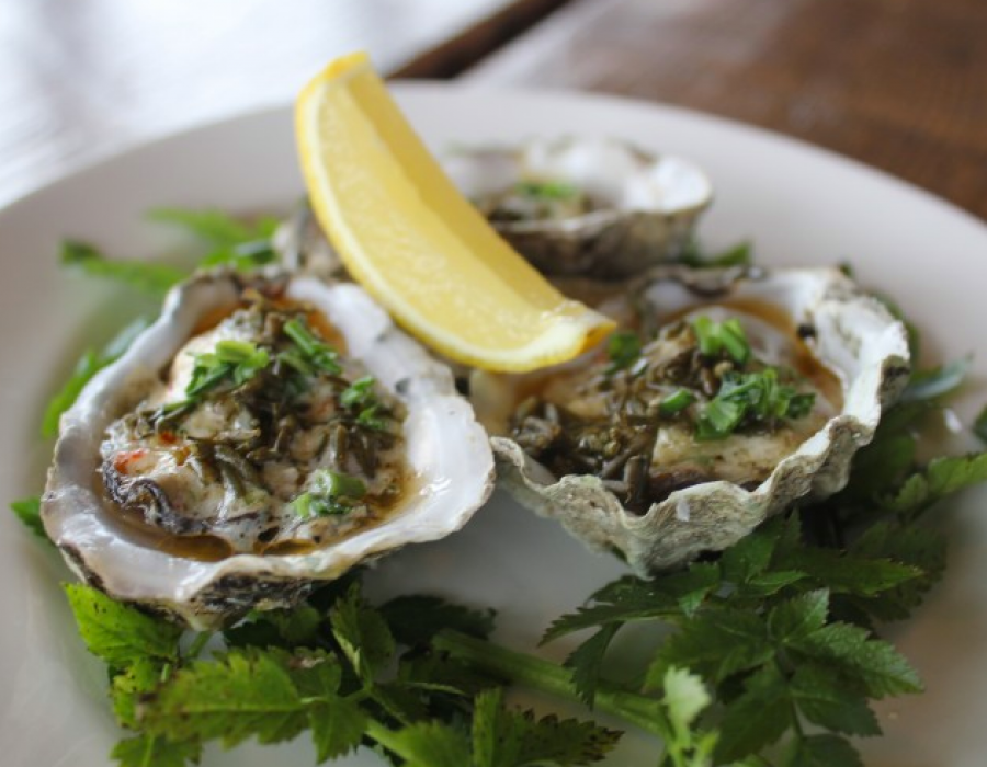 An image of an oyster dish with a lemon wedge on top.